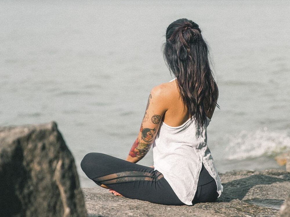 Free tattooed woman doing yoga