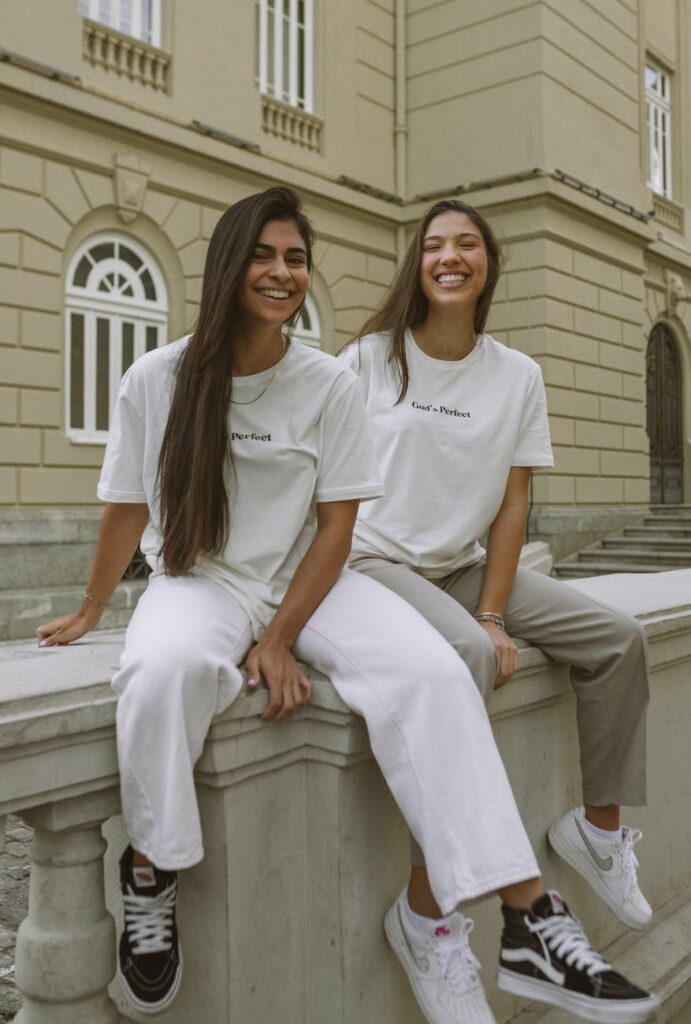 young women in casual fashionable outfits posing in city