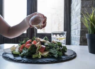 Plant-Based Diets: The Trend That’s Here to Stay person pouring dip on vegetable salad