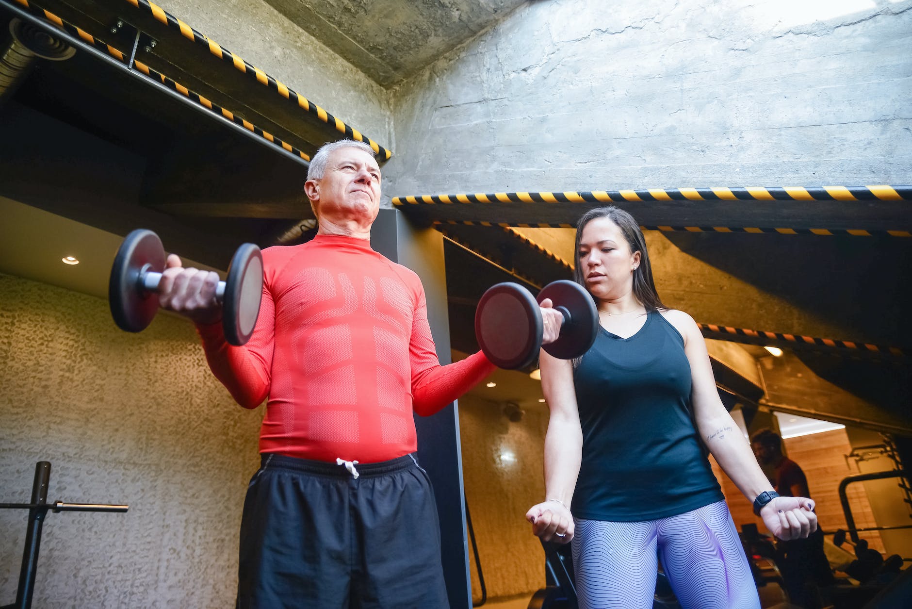 man lifting dumbbells beside a woman