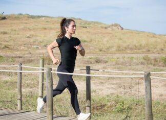 Outdoor Fitness and Activities woman in black activewear running on a boardwalk