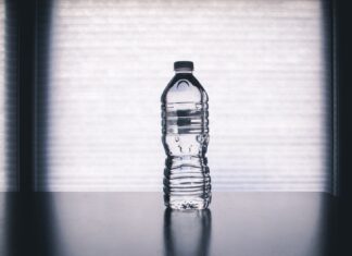 Bottled Water Contains Microplastics. Here’s How to Make It Safe. clear disposable bottle on black surface