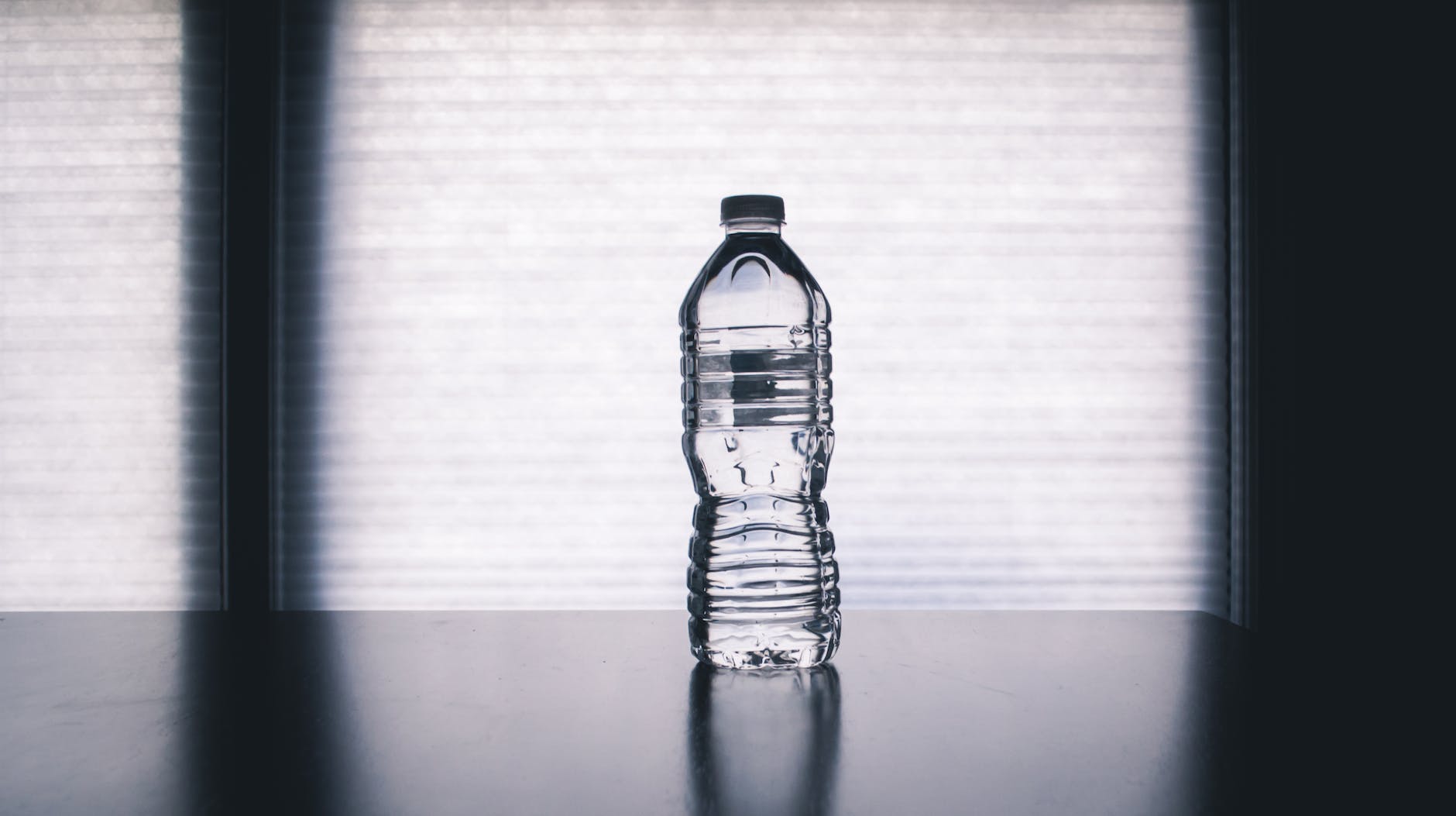 clear disposable bottle on black surface