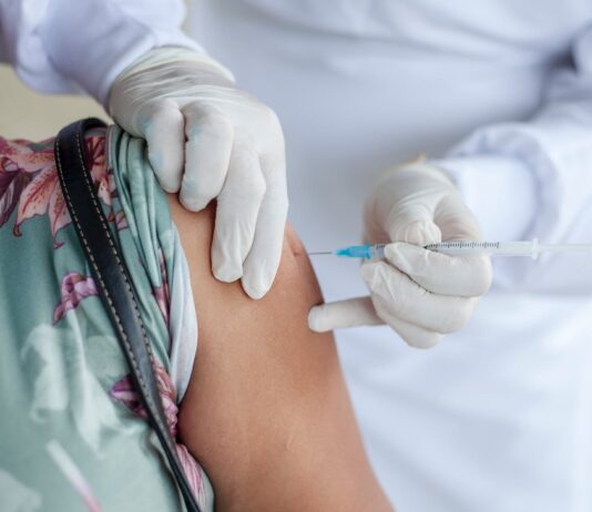 Recommended Wait Time for COVID Vaccination After Exposure person getting vaccinated