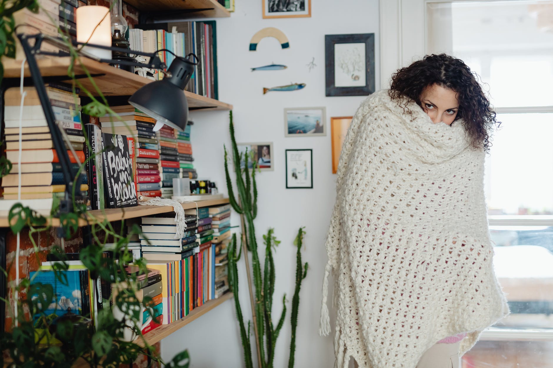 woman feeling cold at home with shawl wrapped around her