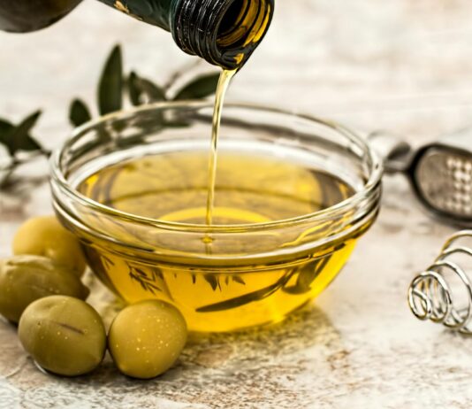 Why You Should Start Taking a Shot of Olive Oil Daily to Live Longer bowl being poured with yellow liquid