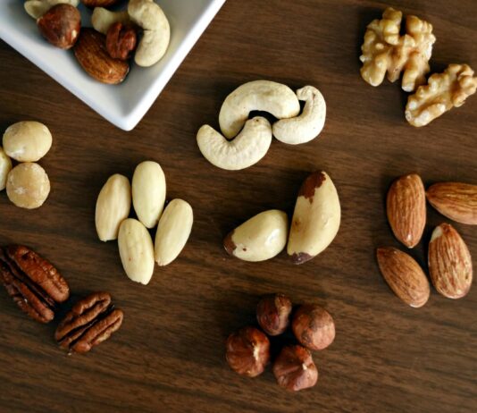 4 Health Benefits of Brazil Nuts variety of brown nuts on brown wooden panel high angle photo